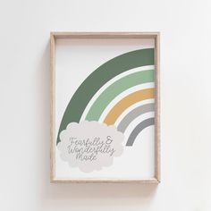 a wooden frame hanging on the wall with a rainbow and clouds in front of it