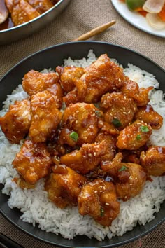 a black plate topped with chicken and rice