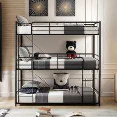 a black metal bunk bed with a teddy bear sitting on it's bottom shelf