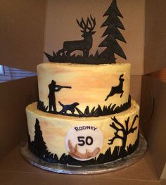 there is a three layer cake decorated with deer and hunting silhouettes on the side