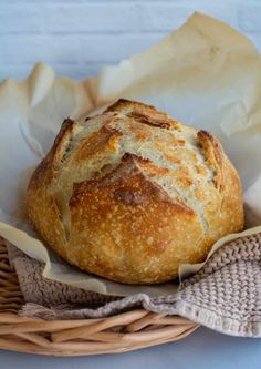 a loaf of bread sitting in a basket on top of a table next to a napkin