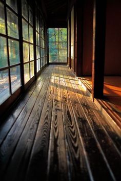 a room with wooden floors and large windows in the center, there is a mask on the floor