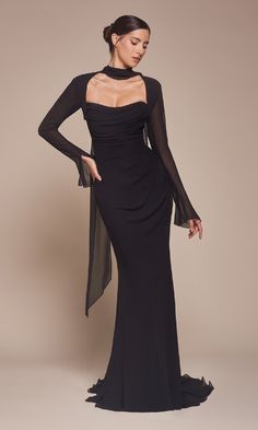 a woman in a long black dress with sheer sleeves