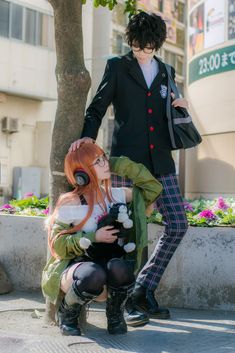 two people dressed in costumes standing next to each other near a tree and planter