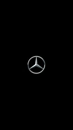 the mercedes logo is shown on a black background in this image, it appears to be an emblem