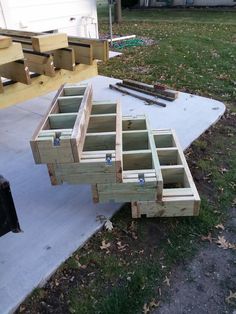 some wooden boxes sitting on top of a cement slab in the middle of a yard