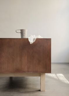 a wooden table with a bucket and tissue on it