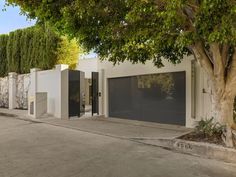 an empty street with two garages and trees