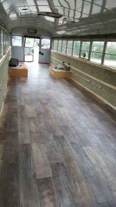 an empty bus with wooden floors and windows