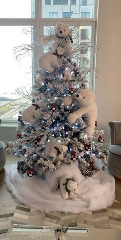 a white christmas tree decorated with teddy bears