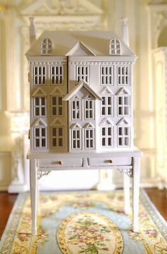 a doll house sitting on top of a table in front of a carpeted area