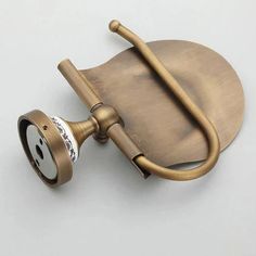 an old fashioned brass toilet paper dispenser on a white background with the lid open