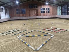 an indoor arena with multiple obstacles in the middle and several poles sticking out of the ground