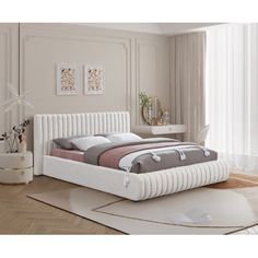 a white bed sitting on top of a wooden floor