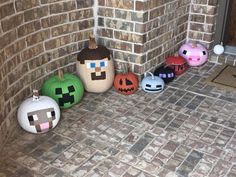 a group of pumpkins sitting on top of a brick floor next to a door