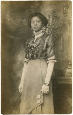 an old photo of a woman wearing a dress