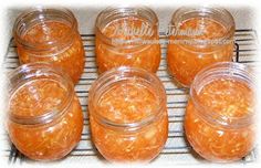 six jars filled with orange colored food sitting on top of a cooling rack next to each other