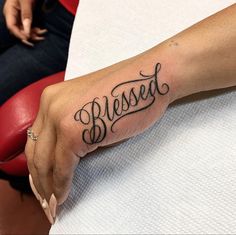 a woman's hand with a tattoo that says, blessed on the left side of her arm