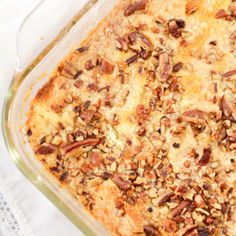 a casserole dish with pecans and other toppings in it on a white cloth