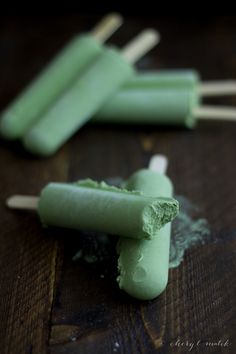 green popsicles sitting on top of a wooden table