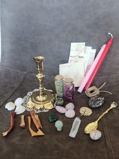 a table topped with lots of different types of jewelry and candles on top of it