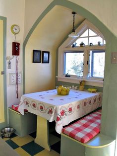 a kitchen with a table and two benches in it, next to a large window