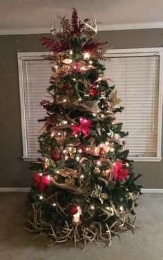 a christmas tree decorated with deer antlers and lights