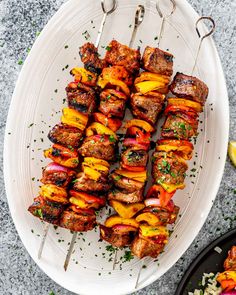 grilled meat and vegetable skewers on a white plate