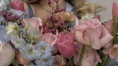 a woman is holding a bunch of flowers