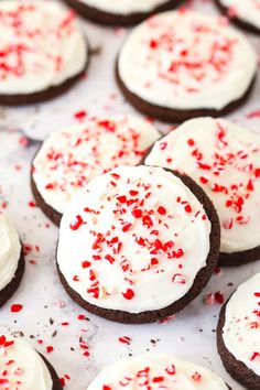 chocolate cookies with white frosting and red sprinkles