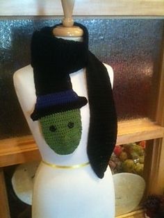 a white mannequin with a black hat and scarf on it's head