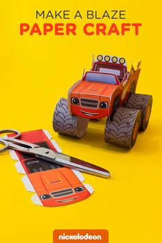 an orange paper craft with a red car on it and a pair of scissors next to it