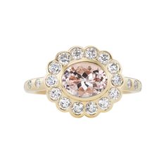 a ring with an oval shaped morganite surrounded by small white and clear stones in the center