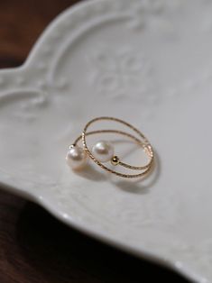 Experience the timeless charm of our 14K Gold-Filled Freshwater Double Pearl Wrapped Wire Ring Elevate any ensemble with its luxurious touch, modern design, adjustable fit, and versatile styling. Make a statement of elegance and sophistication wherever you go. Metal: 14K Gold Filled Gemstone: Freshwater Pearls Pearl Diameter: 5.5-6mm Size: Adjustable 6-8 Weight: 1g Wire Pearl Ring, Elegant 14k Gold Filled Promise Ring, Elegant Adjustable 14k Gold Filled Rings, Elegant Adjustable Yellow Gold Pearl Ring, Elegant Gold-plated Pearl Ring For Formal Occasions, Elegant 14k Gold-filled Promise Ring, Elegant Silver 14k Gold Filled Rings, Elegant 14k Gold Filled Rings For Anniversary, Elegant White Gold-plated Rings