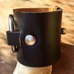 "Chunky leather O-Ring cuff is made with Horween leather and genuine brass hardware. Cuff is 2 inches wide, features a 1.75\" diameter o-ring and is secured with 2 rivets. Fastens with a single Chicago Screw. Horween leather ages beautifully and only becomes softer with wear. The leather will age beautifully and develops fabulous character over time. Brown and whiskey leathers are paired with antique brass hardware and black leather pairs with matte nickel hardware. If you would like a different Everyday Leather Strap Cuff Bracelet, Leather Cuff Bracelet For Everyday, Adjustable Cuff Bracelet With Custom Hardware, Leather Cuff Jewelry With Black Band, Black Leather Bracelets With Custom Hardware, Black Leather Cuff Jewelry, Leather Bracelets Women, Horween Leather, Bracelet Mens