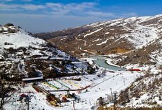 an aerial view of a ski resort with snow on the ground and mountains in the background