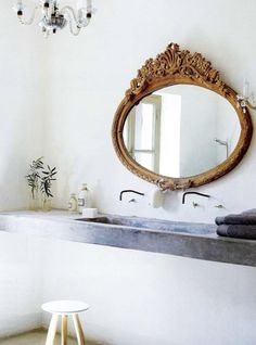 a bathroom sink with a mirror above it and towels hanging on the wall next to it