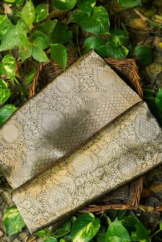 two woven bags sitting on top of green leaves