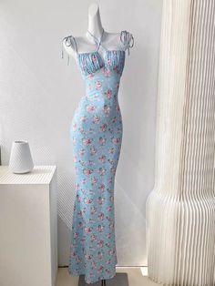 Get ready to turn heads in the Alanis Floral Maxi Dress! This elegant sleeveless dress features a stylish tie-up front detail and adjustable spaghetti straps for the perfect fit. With its backless design and beautiful floral pattern, this dress is perfect for any holiday or sun-filled occasion. Available in both blue and white, you'll rock any event in this versatile and stunning dress. Fitted Summer Maxi Dress With Adjustable Straps, Fitted Sundress With Knotted Straps For Vacation, Fitted Maxi Dress With Knotted Straps For Summer, Casual Fitted Maxi Dress With Knotted Straps, Feminine Fitted Sundress With Halter Neck, Fitted Halter Neck Sundress With Adjustable Straps, Elegant Halter Dress For Spring, Fitted Maxi Dress With Knotted Straps For Spring, Fitted Blue Floral Print Halter Dress