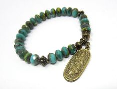 This bead bracelet features an intricately-carved brass charm pendant of Quan Yin, the Buddhist deity known as the Bodhisattva/Goddess of Mercy and Compassion.  Quan Yin is a divinely feminine being, providing comfort in times of stress and chaos and helping to foster love and compassion in oneself and in others.  She is a female version of the Avalokiteshvara Bodhisattva who works selflessly to relieve all sentient beings from suffering.  The beads are Czech Glass, in vibrant shades of green, w Bohemian Rosary Bracelet For Meditation, Spiritual Brass Beaded Bracelets, Spiritual Beaded Brass Bracelets, Spiritual Bronze Nickel-free Bracelets, Nickel-free Bronze Spiritual Bracelets, Divinely Feminine, Avalokiteshvara Bodhisattva, Goddess Of Compassion, Sentient Beings