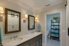 a bathroom with double sinks and two mirrors