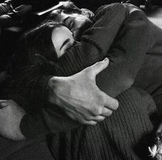 black and white photograph of a woman laying down with her arm around a man's head