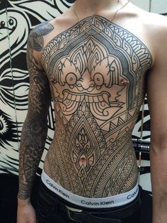 a man with tattoos on his back and chest