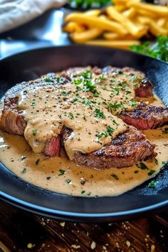 steak with gravy and french fries on the side, ready to be eaten