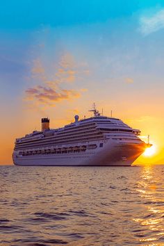 a cruise ship in the ocean at sunset