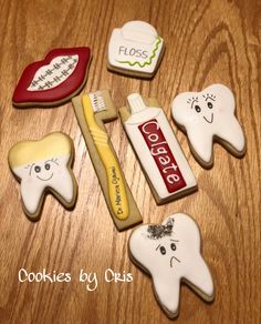 cookies decorated to look like toothbrushes and dental floss on a wooden table