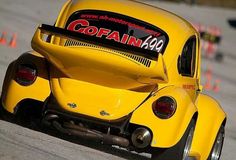 a yellow car driving down a race track with the word gofin on it's back end