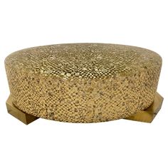 a round ottoman with gold and white designs on it