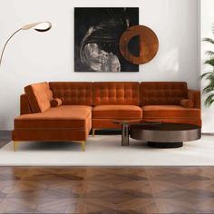 a living room with an orange couch and coffee table in front of a painting on the wall