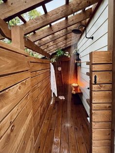 an outdoor shower in the middle of a wooden floored area with wood slats